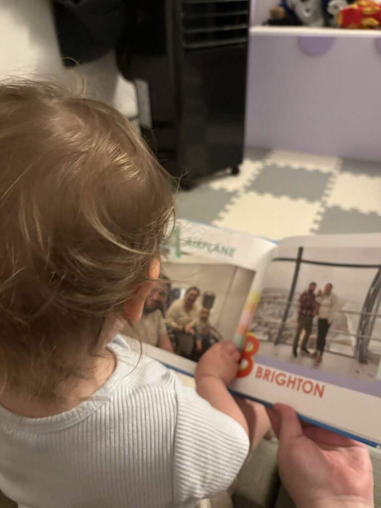 Baby C reading her custom board book with a travel alphabet showing off letters A and B from Mixbook