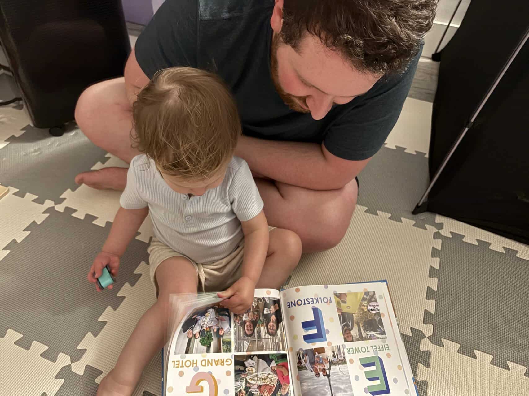 Making A Custom Board Book From Our Travel Photos 2 Colin and Baby C looking at her custom baby board book with the travel alphabet