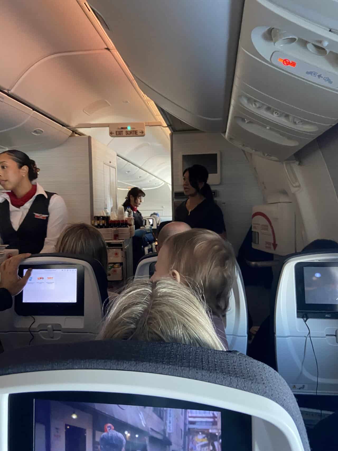 Tips for Flying With a Baby: From Booking to Baggage Claim 44 Baby C sitting with the passenger in front of us, standing on her lap and watching a flight attendant