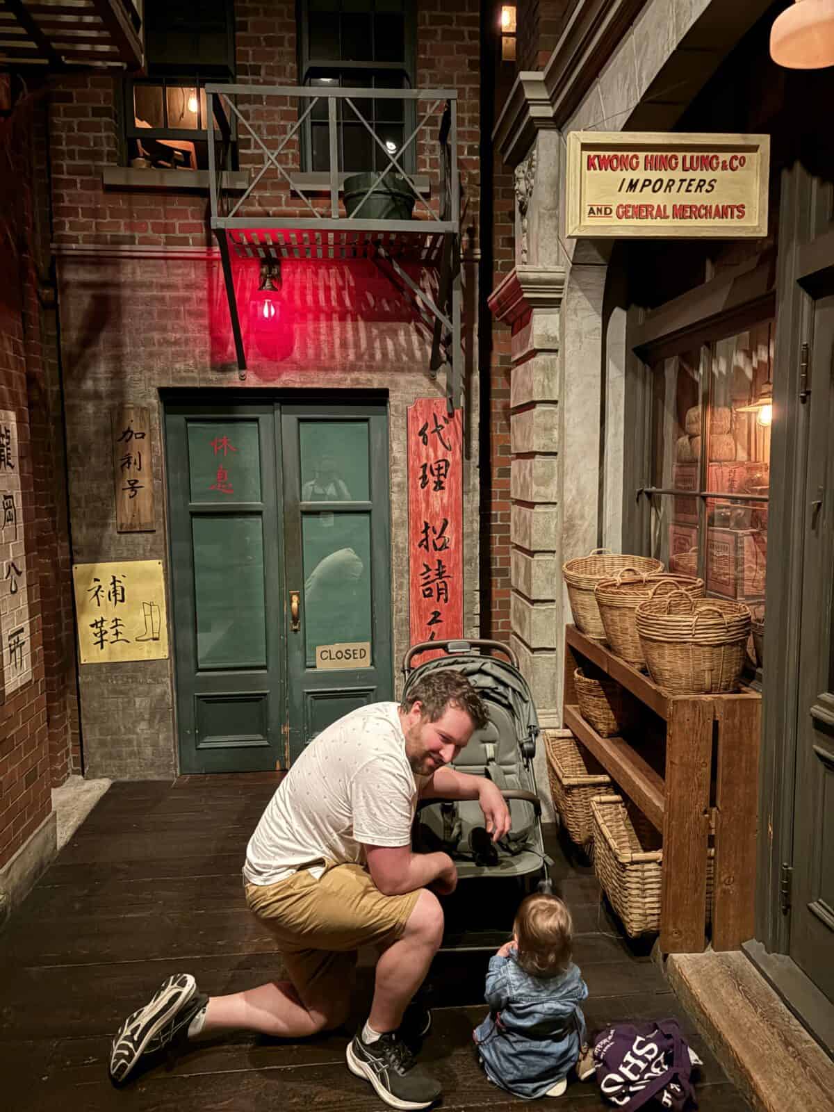 Colin and C kneeling on the ground in Old Town at the Royal BC Museum