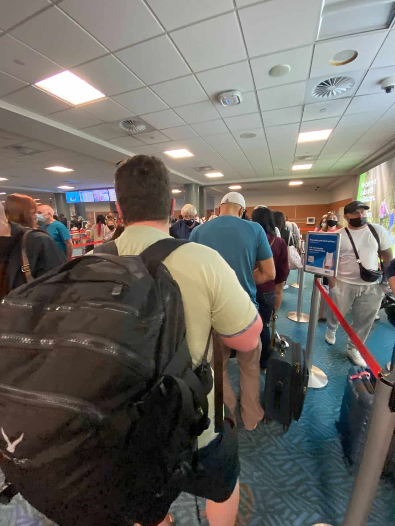 Tips for Flying With a Baby: From Booking to Baggage Claim 31 Colin wearing a large black backpack going through security lines at the airport