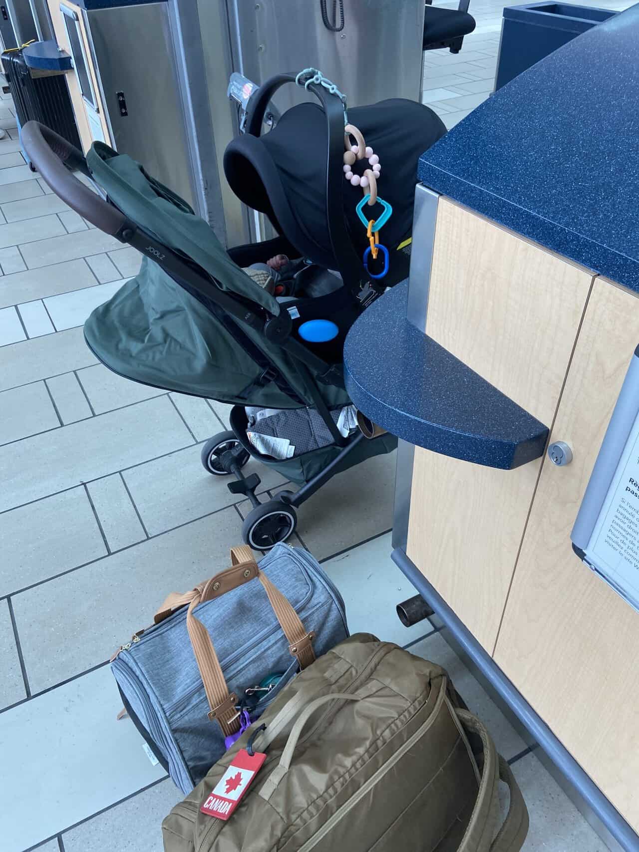 Tips for Flying With a Baby: From Booking to Baggage Claim 5 Baby C's car seat attached to her stroller, our dog carrier and our carry-on backpack at a check in counter at YVR Airport