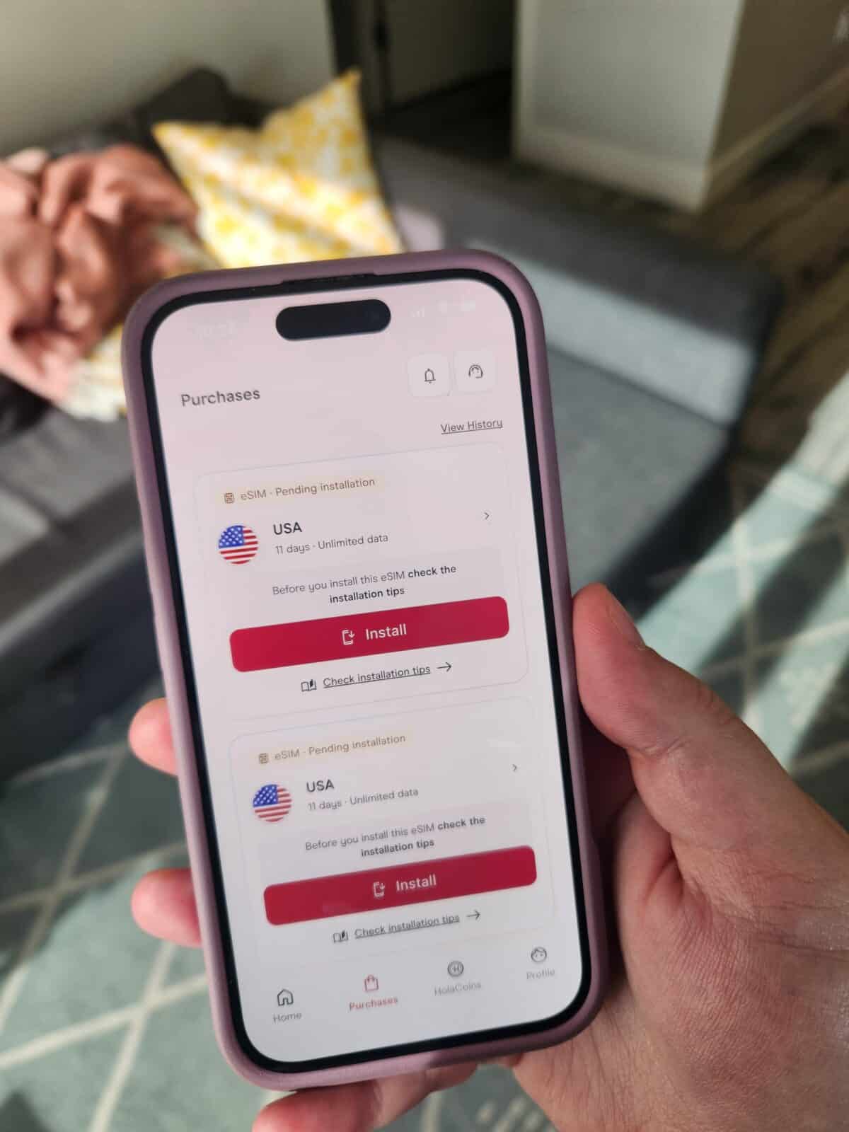 How to Set Up Your Holafly eSIM 8 Riana holding her phone open to the Holafly app showing two eSIMs ready to install