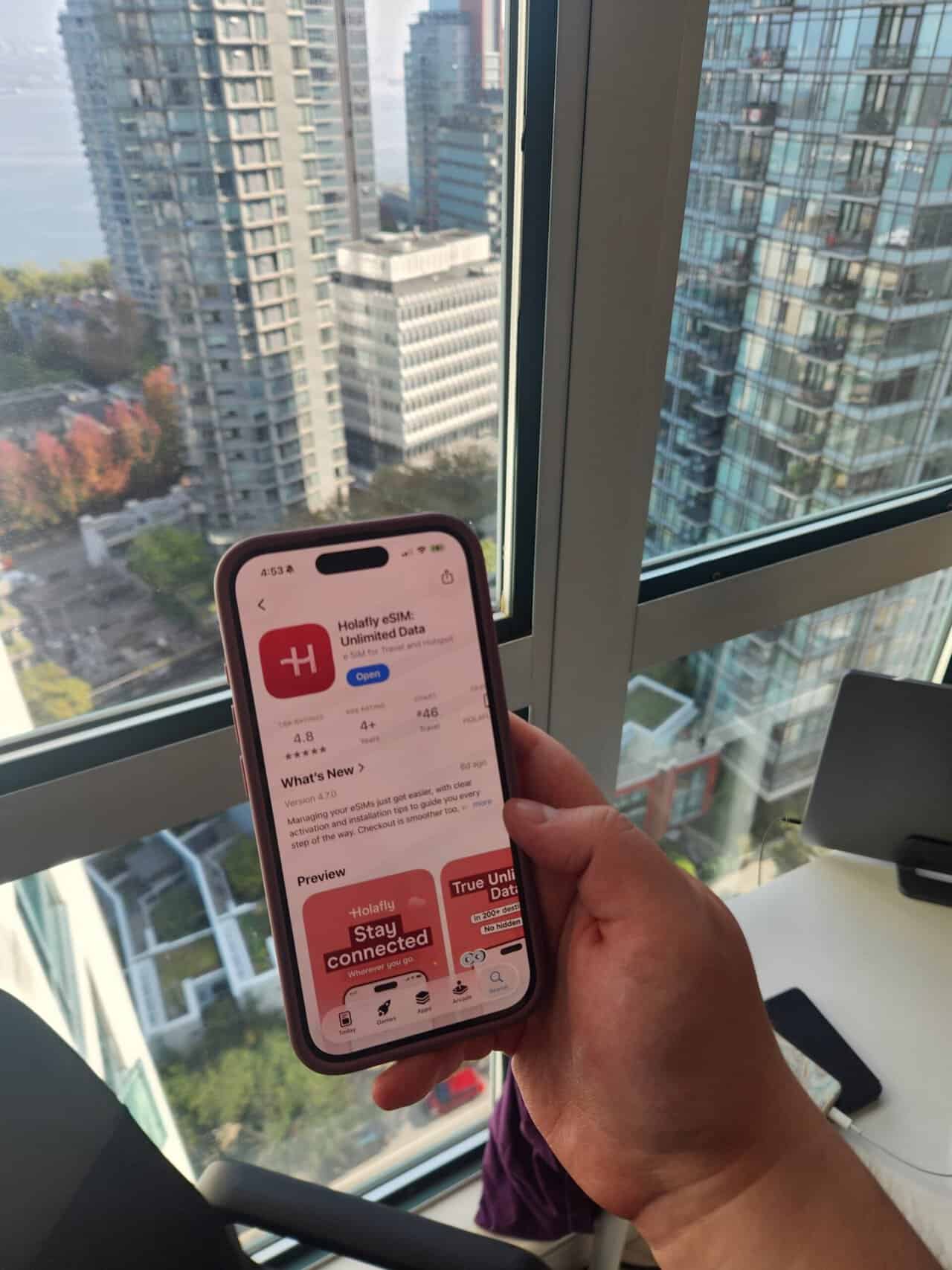 Riana's hand holding a phone with the Holafly eSIM app open on it