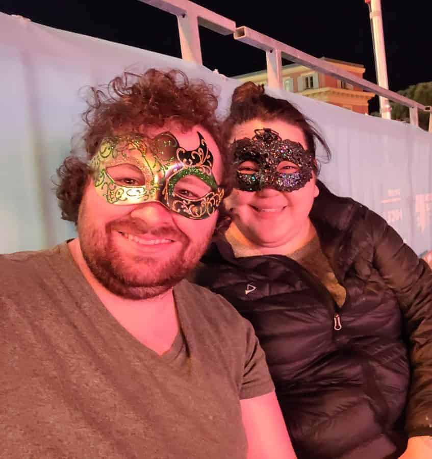 Selfie of Colin and Riana wearing carnival masks at Carnaval de Nice in Nice, France
